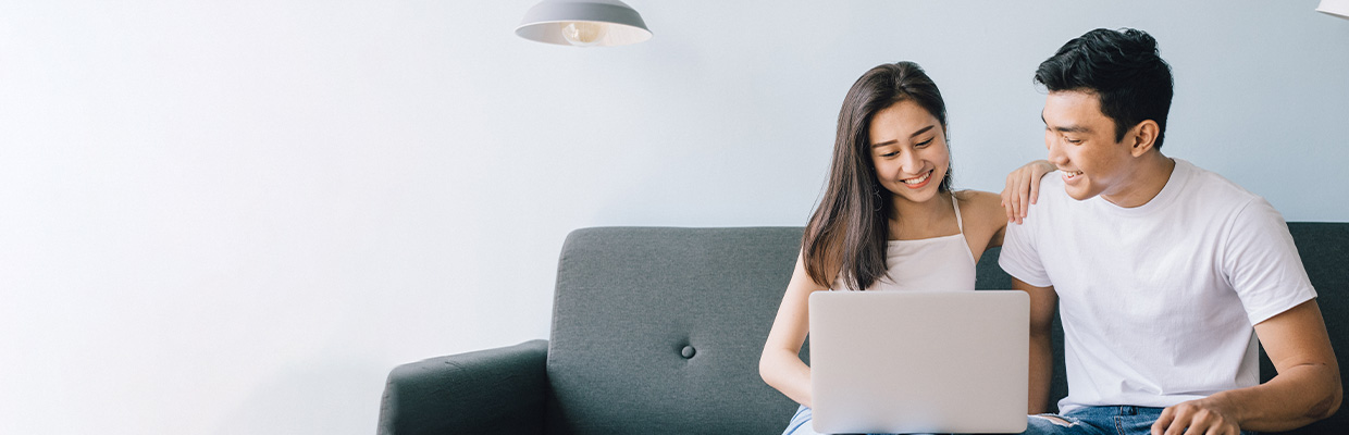 couple using laptop on couch; image used for HSBC Vietnam Loan Comparison page